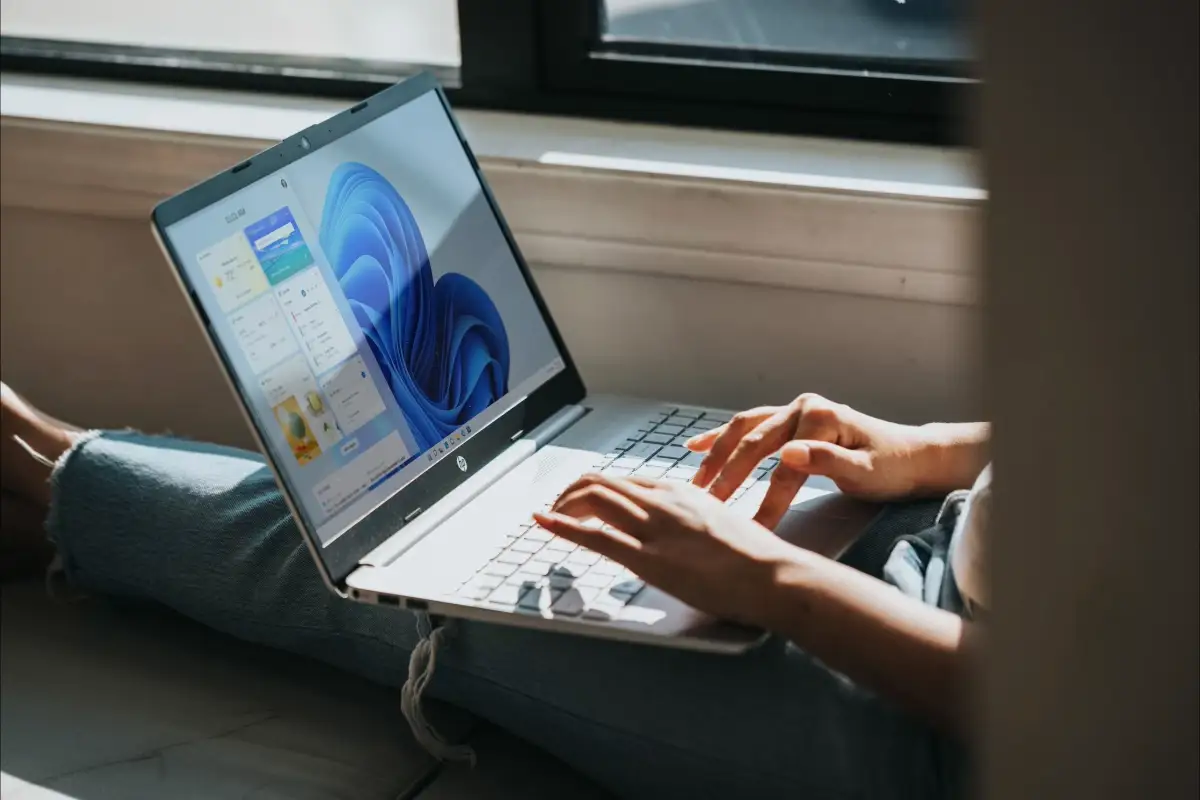 Como desinstalar la IA de Copilot y otro bloatware de Windows Una persona tecleando en su portátil Windows