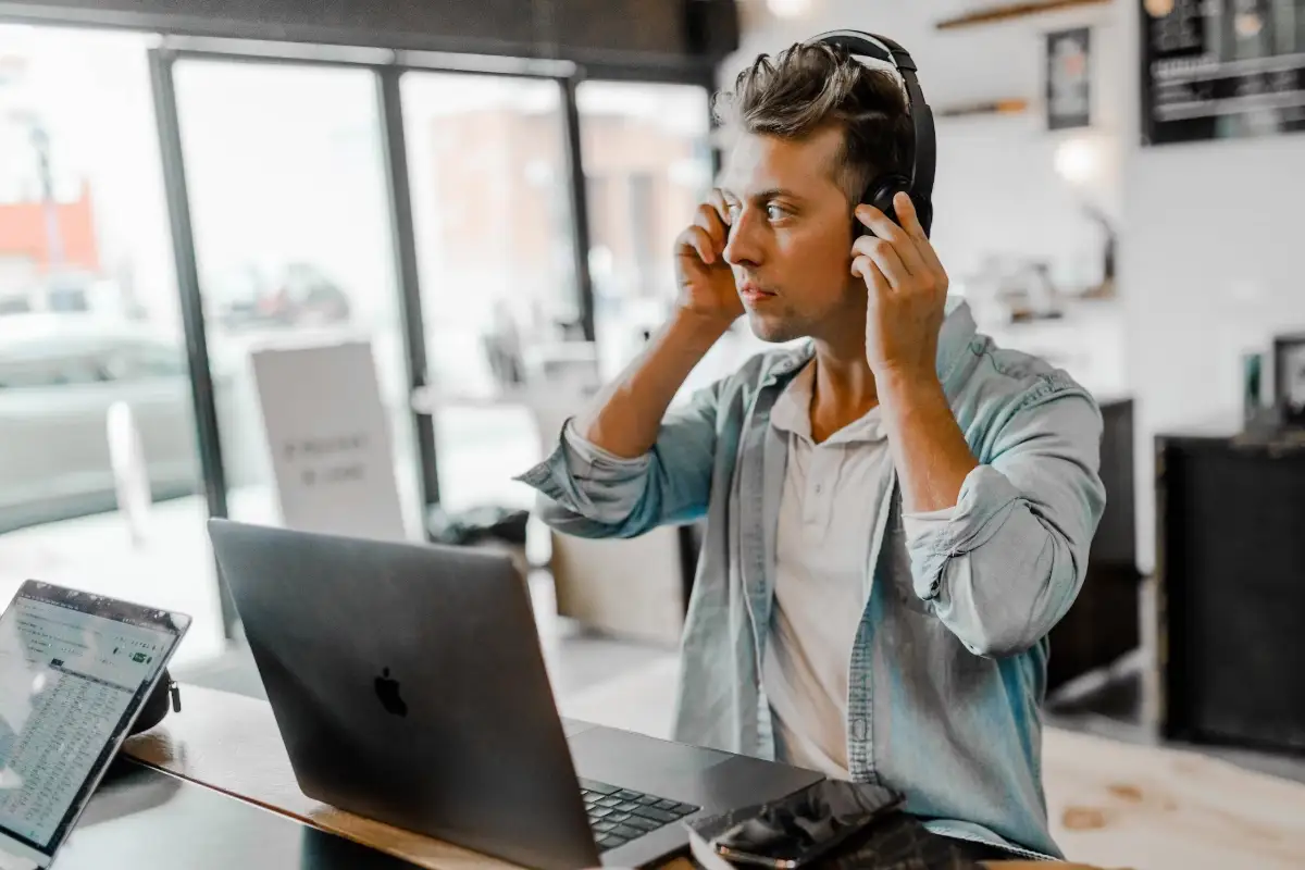Suno generador de musica IA con canciones de 2 minutos Un hombre joven escuchando música en el PC